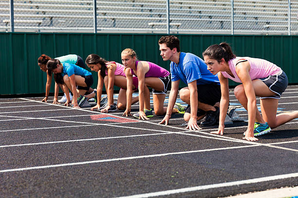 High school girls line up to challenge a high school boy on the track.